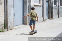 Back of a skater boy riding on the street on a sunny day 47mlzO