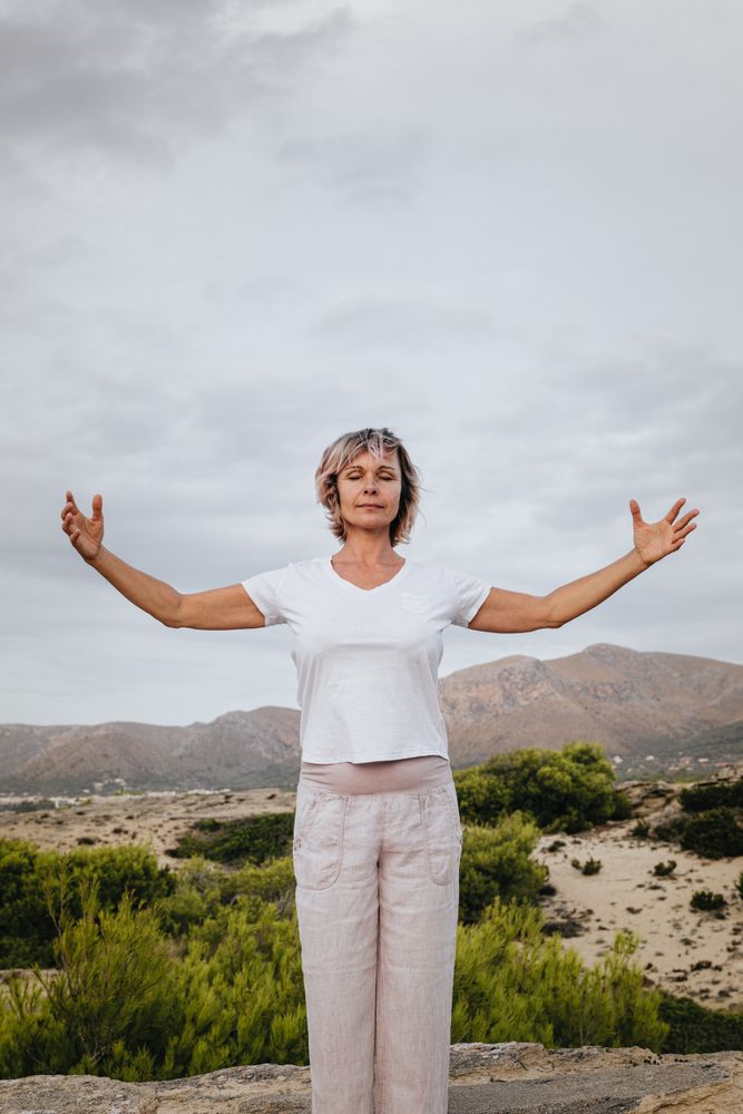 Barefoot woman meditating on stone