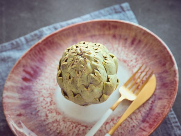 Artichoke on plate with cutlery