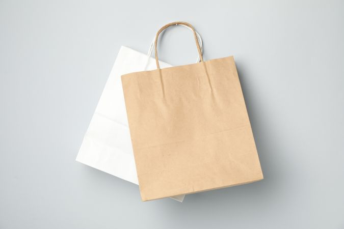 Empty paper bags on gray background, space for text.
