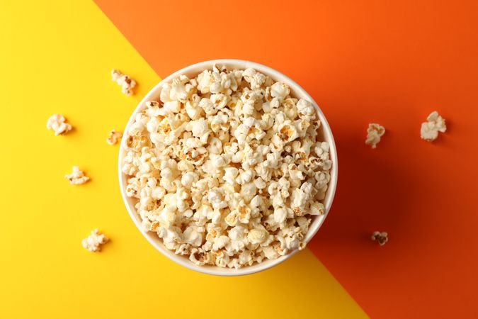 Flat lay composition. Bucket with popcorn on two tone background