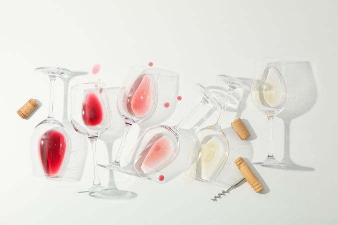 Flat lay composition. Corkscrew, glasses with different wine on blank background