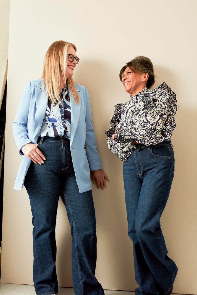 Two stylish women in business casual clothing in studio portrait