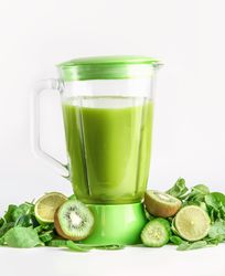 Blender with green smoothie with ingredients:  kiwi, cucumber, lime and spinach