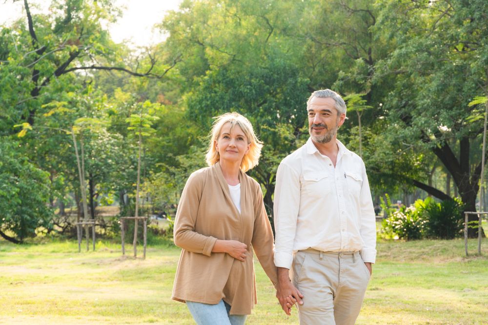 Portrait of man and woman holding hands and walking at park