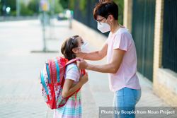 Mother helping young girl with her backpack 4Mv81b