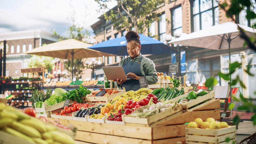 Black Businesswoman Contacting Suppliers Online for her Market Stall