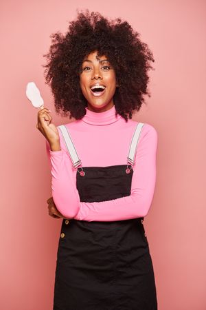 Funny woman with ice cream on stick looking at camera