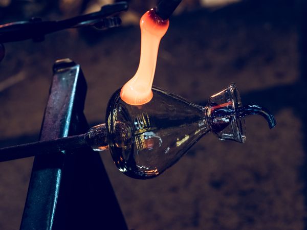 Craftsmen making glass bottle in factory