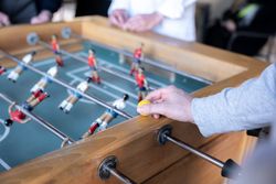 A young man is holding a table football ball before starting the game