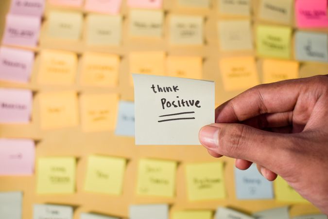 Hand hold sticky notes with words Think Positive
