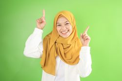 Asian Young Muslim  in Veil Woman Pointing on Copy Space
