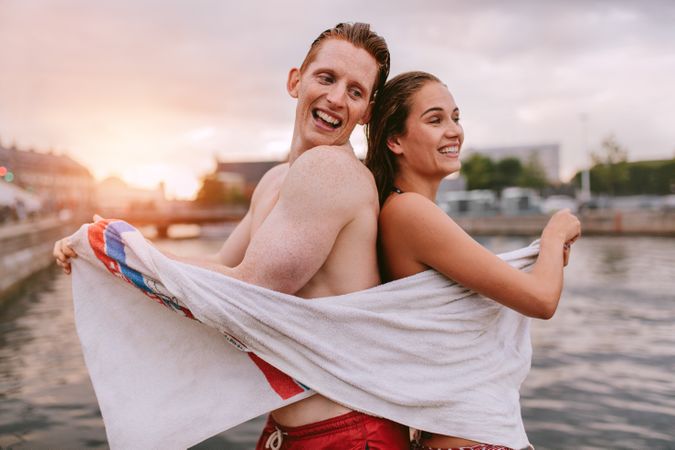 Couple sharing a towel after swimming