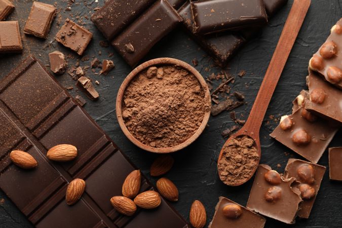 Chocolate, melted chocolate and almond on dark background