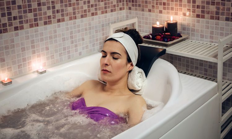 Female resting in therapeutic bath in spa