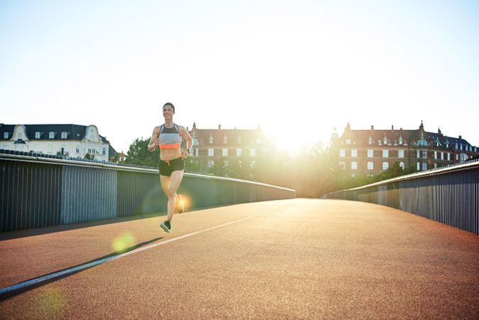 Smiling woman on her morning jog on a bridge