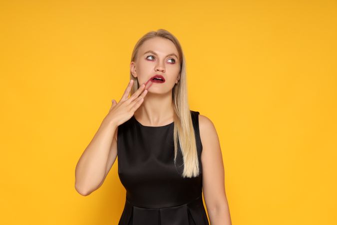 Concept of Halloween, young woman on yellow background