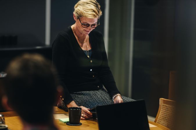 Woman sitting on conference table using digital tablet during a meeting