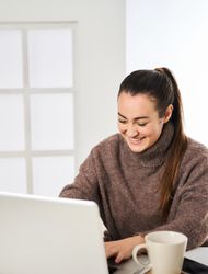 a smiling woman working energetically on her personal computer f