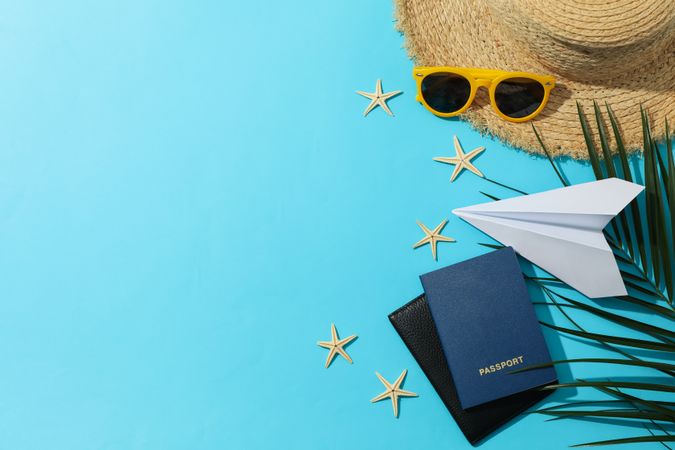 Summer travel accessories on blue background, space for text