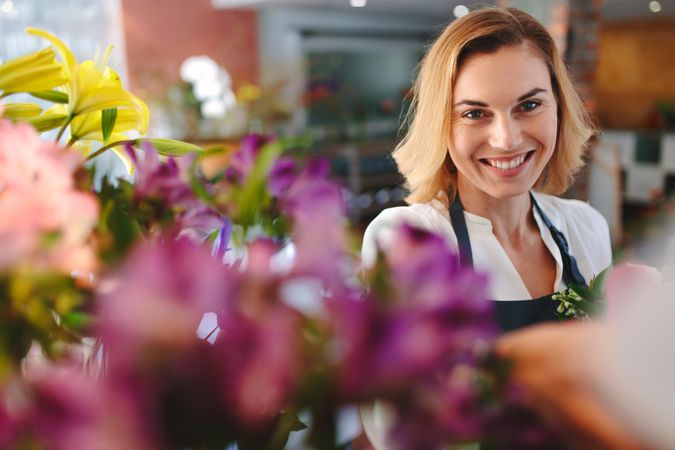 Blonde woman smiling at florist shop
