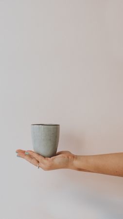Big gray mug in outstretched hand