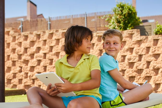 Boys using tablet in garden
