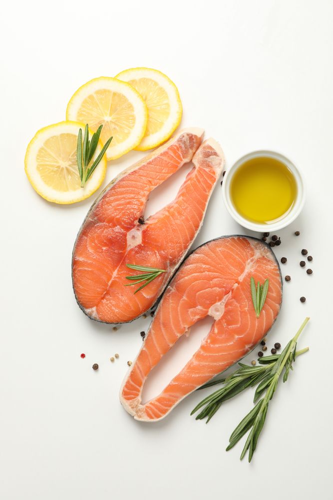 Composition with salmon meat and spices on light background, top view