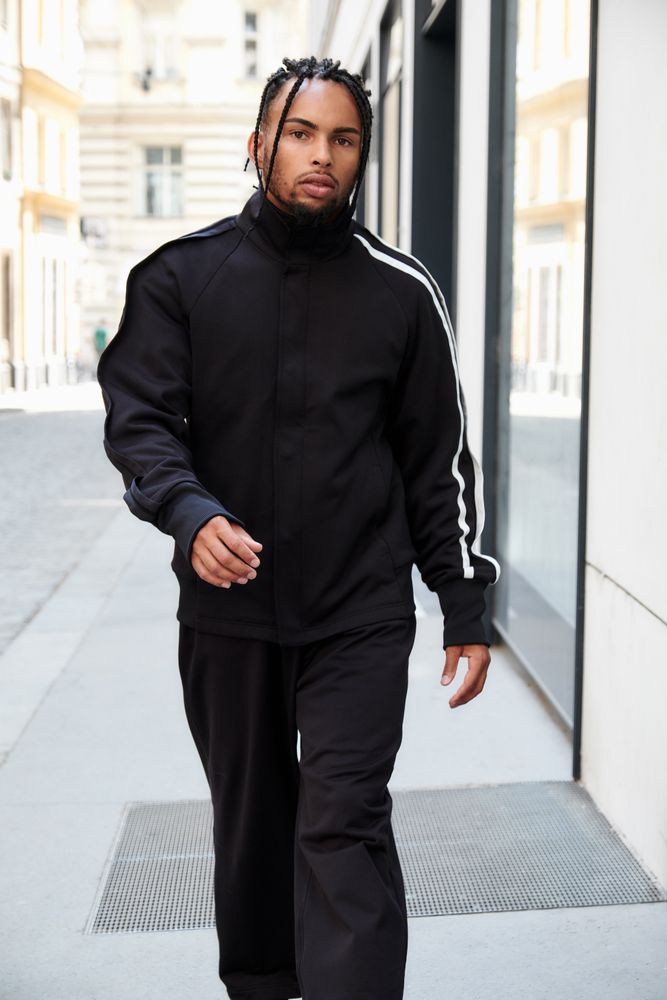 Black braided male walking down street