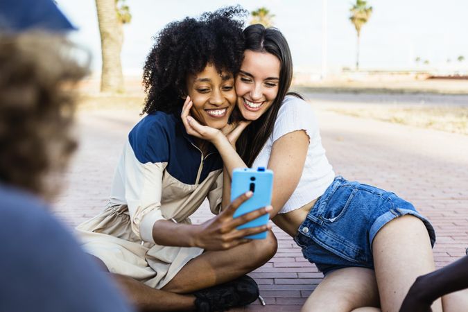 Happy multiracial women taking a selfie with smart phone outdoors