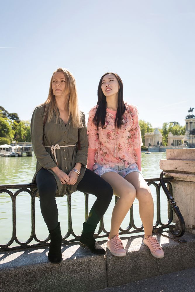 Cheerful multiracial friends sitting on embankment