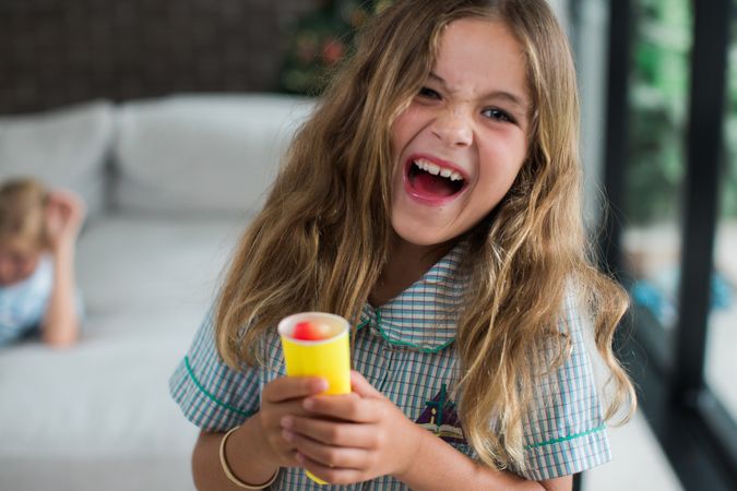 Girl in  plaid button up shirt holding ice cream