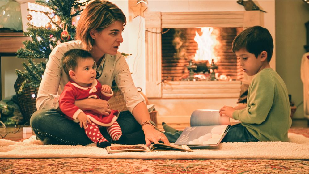 Mother reading book with son on Christmas eve