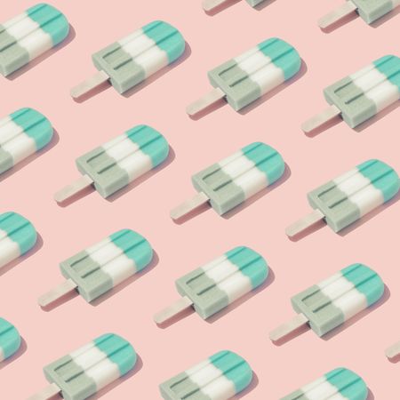 Pattern of colorful ice cream popsicle on pastel pink background