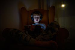 Boy playing on tablet at night