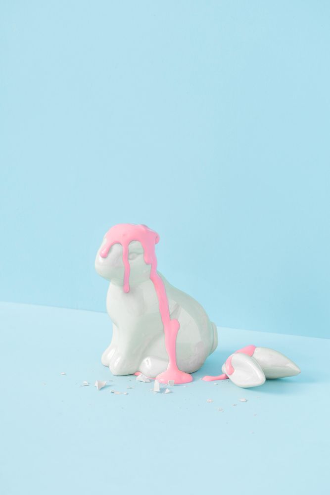 Easter bunny with broken ears on blue background and baby pink blood