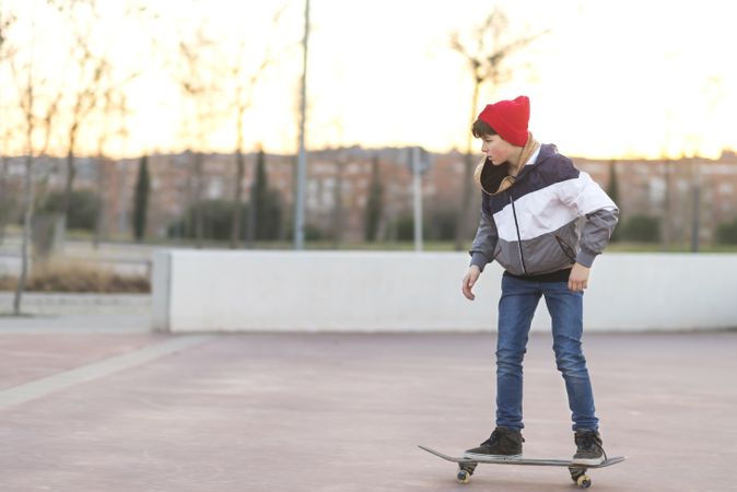 Side view of young man riding on skateboard in street