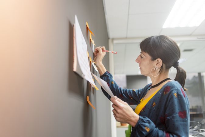 Businesswoman writing on sticky notes