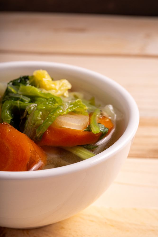 A bowl of soup with vegetables in it