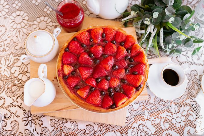 from above a strawberries cake on table with coffee and milk