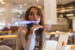 Female student looking around from her restaurant table