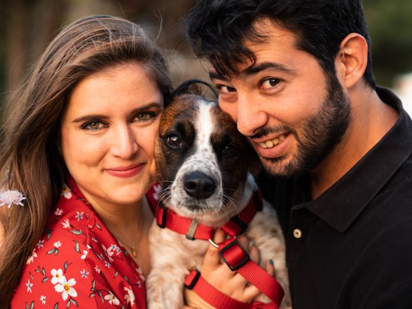 Happy couple with friendly cute dog outdoors