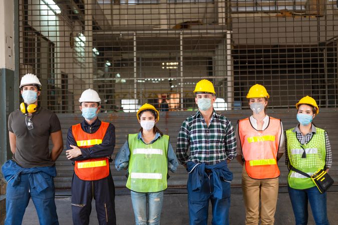 Group of industrial workers wearing protective gear standing in line