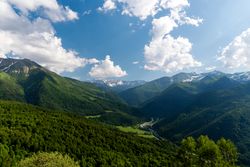 Mountain valley with lush green hills and snow-capped peaks