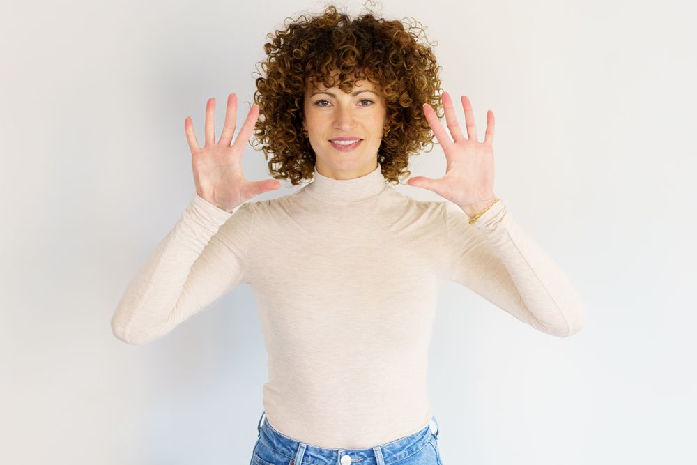 Woman in casual clothes holding up both hands