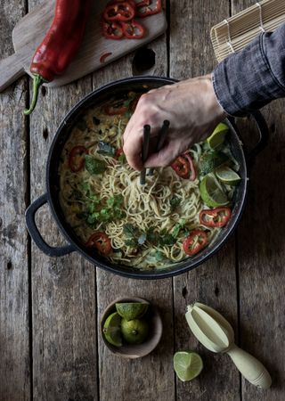Green curry noodles in pot on table