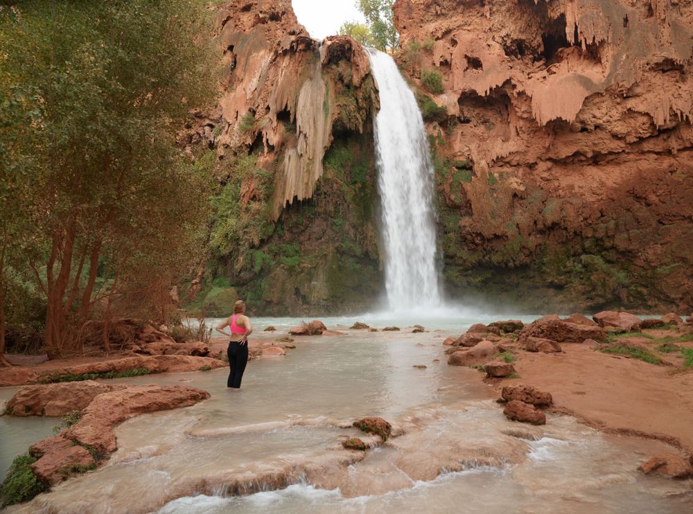 Woman standing below Havasu Falls in Arizona