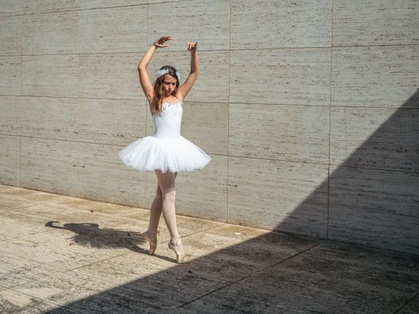 Ballerina doing ballet posing in classroom