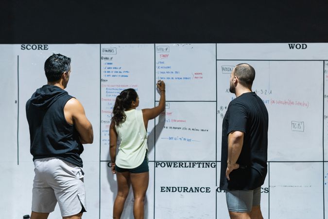 Group of faceless sportspeople near wall with results