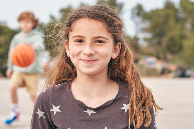 Delighted teen girl looking at camera in city